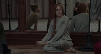 Movie still from “Suspiria” (2018), directed by Luca Guadagnino – A woman sitting on the ground in front of a mirror; Medium shot, High angle