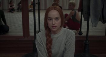 Movie still from “Suspiria” (2018), directed by Luca Guadagnino – A woman with long red hair sitting in front of a mirror; Close Up shot, Over the shoulder angle