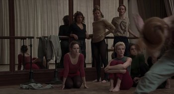 Movie still from “Suspiria” (2018), directed by Luca Guadagnino – A group of women sitting on the floor of a room; Medium shot, High angle