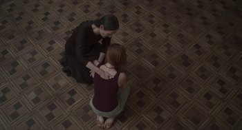 Movie still from “Suspiria” (2018), directed by Luca Guadagnino – Two women sitting on the ground in a room; Medium shot, Overhead angle
