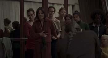 Movie still from “Suspiria” (2018), directed by Luca Guadagnino – A group of women standing next to each other in a room; Medium shot, Over the shoulder angle