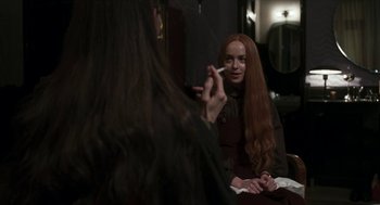 Movie still from “Suspiria” (2018), directed by Luca Guadagnino – A woman with long red hair sitting in front of a mirror; Medium shot, Over the shoulder angle