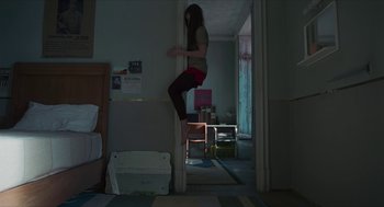Movie still from “Suspiria” (2018), directed by Luca Guadagnino – A woman standing on a wall in a room; Wide shot, Overhead angle