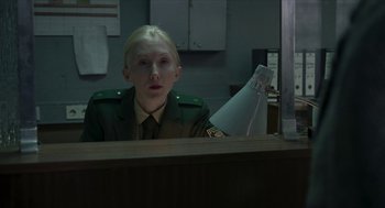 Movie still from “Suspiria” (2018), directed by Luca Guadagnino – A person sitting at a desk in front of a computer monitor; Medium shot, Over the shoulder angle