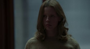 Movie still from “Suspiria” (2018), directed by Luca Guadagnino – A woman with long blonde hair wearing a sweater; Close Up shot, Low angle