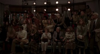 Movie still from “Suspiria” (2018), directed by Luca Guadagnino – A group of people sitting in chairs in a room; Wide shot, High angle