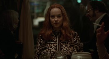 Movie still from “Suspiria” (2018), directed by Luca Guadagnino – A woman sitting at a table with a glass of wine in front of her; Close Up shot, Over the shoulder angle