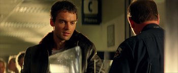 Movie still from “Swordfish” (2001), directed by Dominic Sena – A person sitting in a room; Close Up shot, Over the shoulder angle