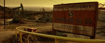 Movie still from “Swordfish” (2001), directed by Dominic Sena – An old sign is posted on the side of the road; Extreme Wide shot, High angle