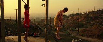 Movie still from “Swordfish” (2001), directed by Dominic Sena – A man in a yellow bathing suit is playing golf on a hill; Wide shot, Low angle