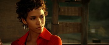 Movie still from “Swordfish” (2001), directed by Dominic Sena – A man in a red shirt is looking to his left; Close Up shot, Over the shoulder angle