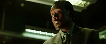 Movie still from “Swordfish” (2001), directed by Dominic Sena – A person wearing a suit and tie; Close Up shot, Low angle