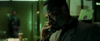 Movie still from “Swordfish” (2001), directed by Dominic Sena – A man is talking on a phone while wearing a suit; Close Up shot, High angle