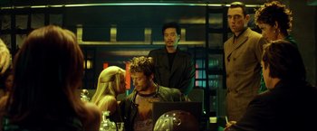 Movie still from “Swordfish” (2001), directed by Dominic Sena – A group of people sitting around a table; Medium shot, Over the shoulder angle