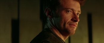 Movie still from “Swordfish” (2001), directed by Dominic Sena – A man's face in a dark room; Close Up shot, Low angle