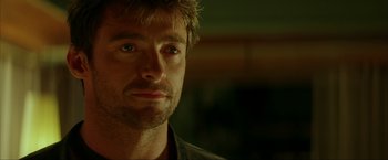 Movie still from “Swordfish” (2001), directed by Dominic Sena – A man's face in a dark room; Close Up shot, Over the shoulder angle