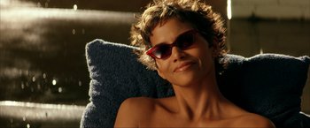Movie still from “Swordfish” (2001), directed by Dominic Sena – A person wearing sunglasses on a chair; Close Up shot, High angle