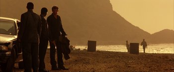 Movie still from “Swordfish” (2001), directed by Dominic Sena – A man standing on a beach holding a kite; Wide shot, Low angle