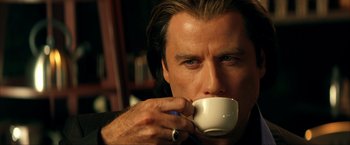 Movie still from “Swordfish” (2001), directed by Dominic Sena – A person drinking a cup of coffee; Close Up shot, Low angle