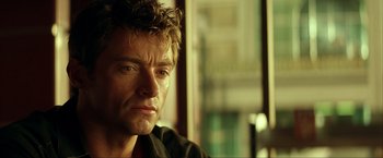 Movie still from “Swordfish” (2001), directed by Dominic Sena – A man's face in front of a window; Close Up shot, Over the shoulder angle