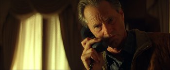 Movie still from “Swordfish” (2001), directed by Dominic Sena – An older man talking on a phone while standing in a room; Close Up shot, Low angle