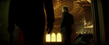 Movie still from “Swordfish” (2001), directed by Dominic Sena – A man standing in front of stained glass windows; Wide shot, Low angle