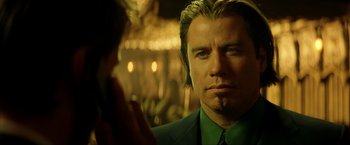 Movie still from “Swordfish” (2001), directed by Dominic Sena – A person wearing a suit and tie; Close Up shot, Over the shoulder angle