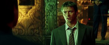 Movie still from “Swordfish” (2001), directed by Dominic Sena – A person wearing a suit and tie; Close Up shot, Low angle