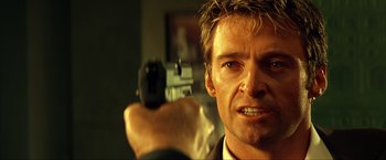 Movie still from “Swordfish” (2001), directed by Dominic Sena – A person holding a gun; Close Up shot, Over the shoulder angle