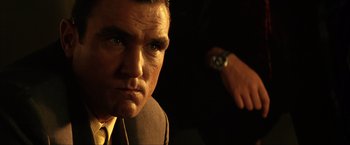 Movie still from “Swordfish” (2001), directed by Dominic Sena – A person wearing a suit and tie; Close Up shot, Low angle