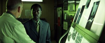 Movie still from “Swordfish” (2001), directed by Dominic Sena – A man wearing a suit and tie standing in front of an elevator; Medium shot, Low angle