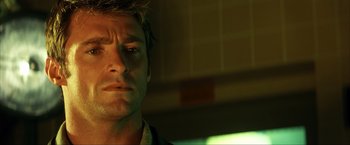 Movie still from “Swordfish” (2001), directed by Dominic Sena – A man's face in a dark room; Close Up shot, Low angle