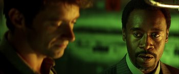 Movie still from “Swordfish” (2001), directed by Dominic Sena – Two men are looking at each other in the dark; Close Up shot, Over the shoulder angle