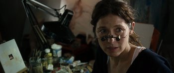 Movie still from “Synecdoche, New York” (2008), directed by Charlie Kaufman – A woman with glasses is looking at the camera; Close Up shot, Over the shoulder angle