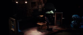 Movie still from “Synecdoche, New York” (2008), directed by Charlie Kaufman – A man standing at a table in a dark room; Extreme Wide shot, High angle