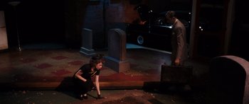 Movie still from “Synecdoche, New York” (2008), directed by Charlie Kaufman – A woman crouching down in front of a grave; Wide shot, High angle