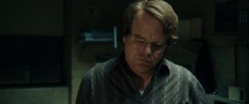 Movie still from “Synecdoche, New York” (2008), directed by Charlie Kaufman – A man with glasses is looking down at his face; Close Up shot, Low angle