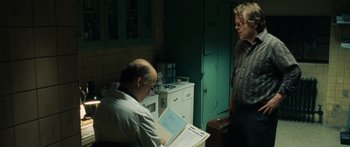 Movie still from “Synecdoche, New York” (2008), directed by Charlie Kaufman – A man and a woman looking at papers in a kitchen; Medium shot, Over the shoulder angle