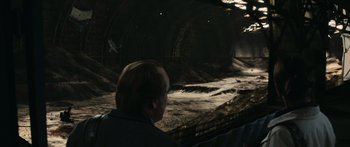 Movie still from “Synecdoche, New York” (2008), directed by Charlie Kaufman – A man sitting in front of an underground tunnel; Extreme Wide shot, High angle