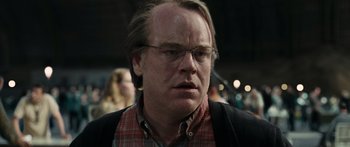 Movie still from “Synecdoche, New York” (2008), directed by Charlie Kaufman – A person wearing glasses and a plaid shirt; Close Up shot, Low angle