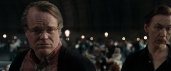 Movie still from “Synecdoche, New York” (2008), directed by Charlie Kaufman – A man in a crowd of people in front of a crowd; Close Up shot, Over the shoulder angle