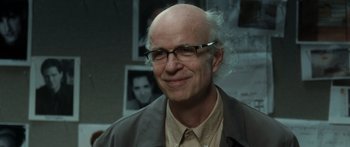 Movie still from “Synecdoche, New York” (2008), directed by Charlie Kaufman – An older man wearing glasses and smiling for the camera; Close Up shot, Over the shoulder angle