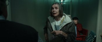 Movie still from “Synecdoche, New York” (2008), directed by Charlie Kaufman – An older woman standing in a hallway talking to someone; Medium shot, Over the shoulder angle