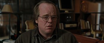 Movie still from “Synecdoche, New York” (2008), directed by Charlie Kaufman – A person wearing glasses and a jacket; Close Up shot, Over the shoulder angle