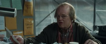 Movie still from “Synecdoche, New York” (2008), directed by Charlie Kaufman – An older man sitting at a table with a plate in front of him; Close Up shot, Over the shoulder angle