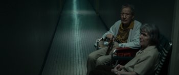 Movie still from “Synecdoche, New York” (2008), directed by Charlie Kaufman – An old man sitting in a chair in a hallway; Medium shot, High angle