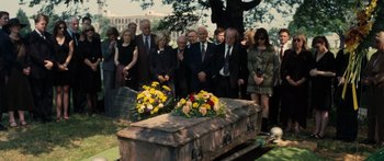 Movie still from “Synecdoche, New York” (2008), directed by Charlie Kaufman – A group of people standing around a coffin; Wide shot, High angle