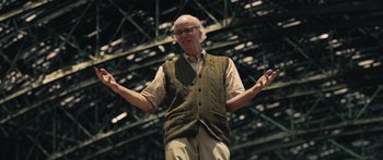 Movie still from “Synecdoche, New York” (2008), directed by Charlie Kaufman – An older man standing in front of an audience; Medium shot, Low angle