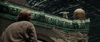 Movie still from “Synecdoche, New York” (2008), directed by Charlie Kaufman – A man riding on top of a skateboard on top of a building; Wide shot, Low angle