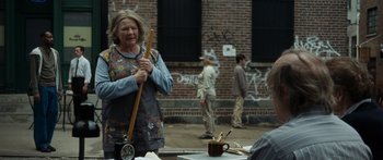 Movie still from “Synecdoche, New York” (2008), directed by Charlie Kaufman – An older woman standing in front of a group of young people; Medium shot, Over the shoulder angle